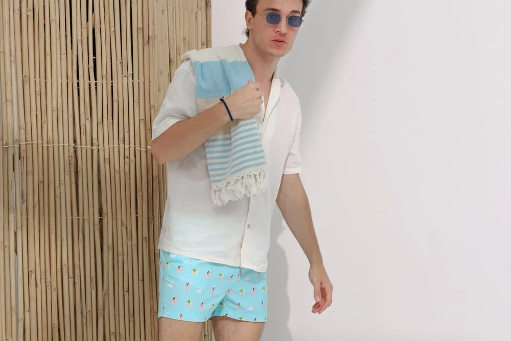 Chaka Bei Aloha Flamingo swim shorts styled with a white linen shirt and striped towel